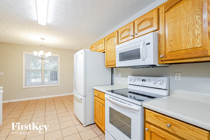 A kitchen with wooden cabinets and white appliances.