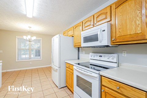 A kitchen with wooden cabinets and white appliances.