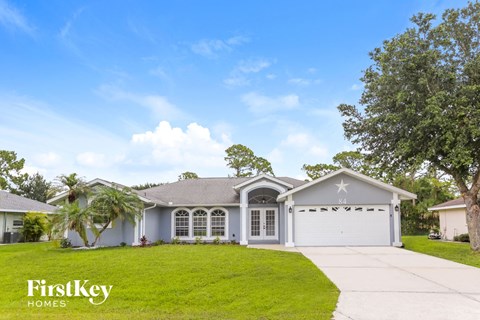 a blue house with a lawn and a white garage door