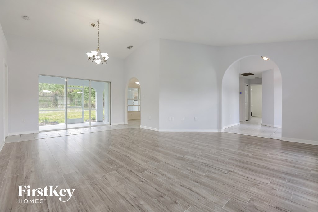 an empty living room with white walls and wood floors