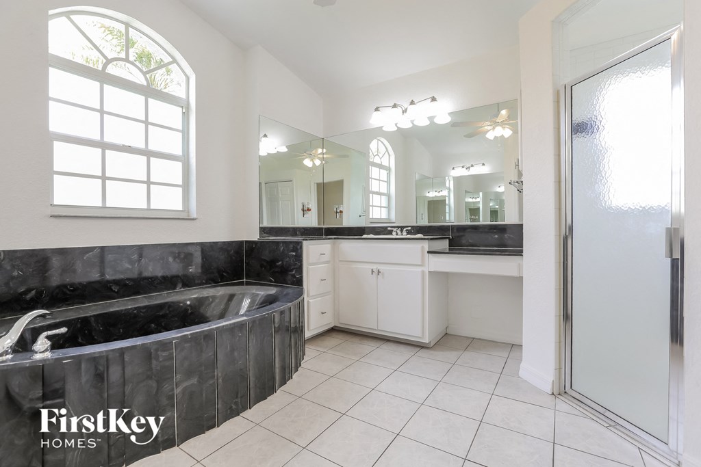 a black and white bathroom with a tub and a sink