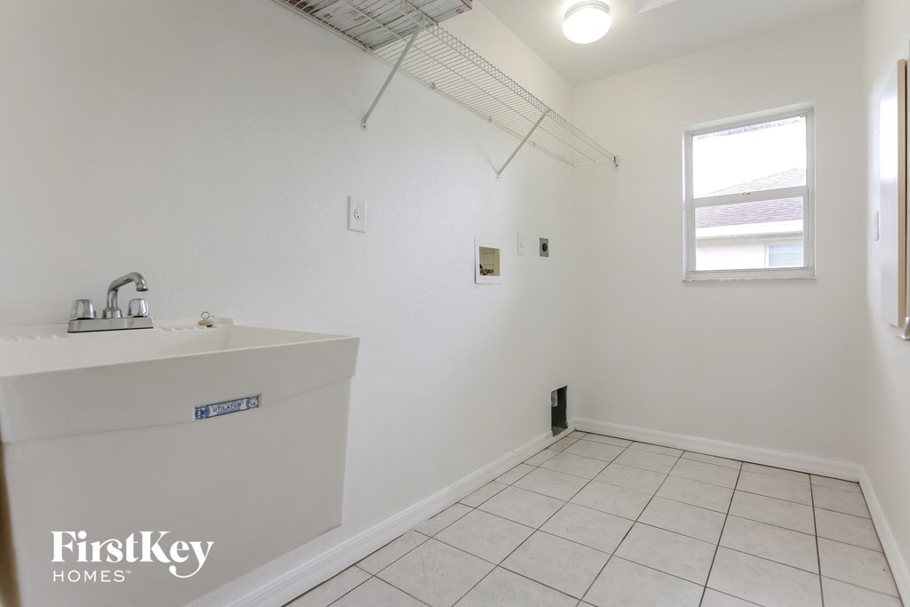 a white bathroom with a sink and a window