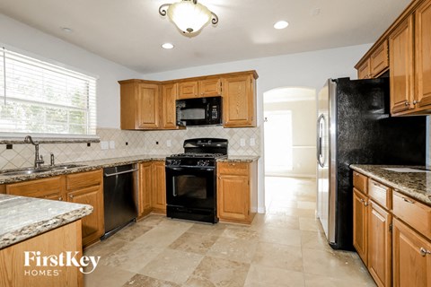 A kitchen with wooden cabinets and black appliances.