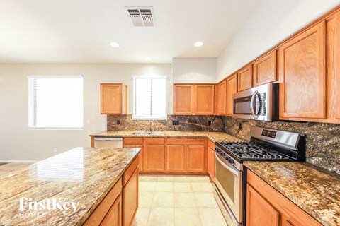 A kitchen with wooden cabinets and granite countertops.