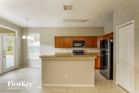 a kitchen with an island and a black refrigerator