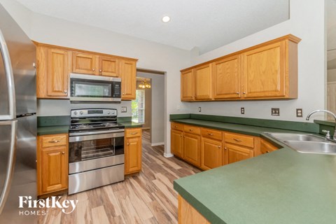 A kitchen with wooden cabinets and a green counter top.