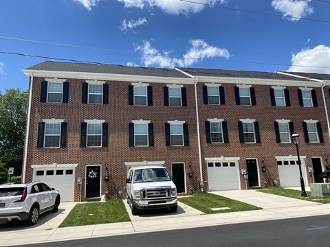 A red brick building with white garage doors and a white truck parked in front.