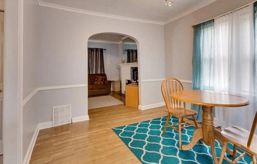 a dining room with a wooden table and a rug