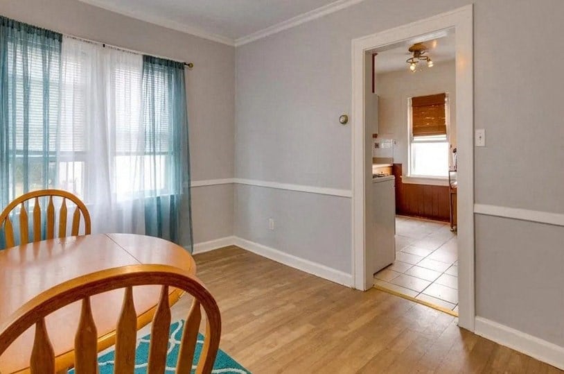 a dining room with a table and a door to a kitchen