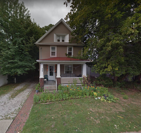 A house with a red roof and a porch with a white railing.