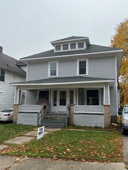 A house with a "For Rent" sign in front.