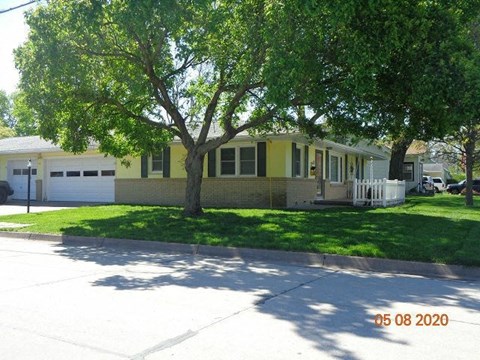 a yellow house with a tree in front of it