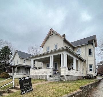 A house with a for rent sign in front of it.