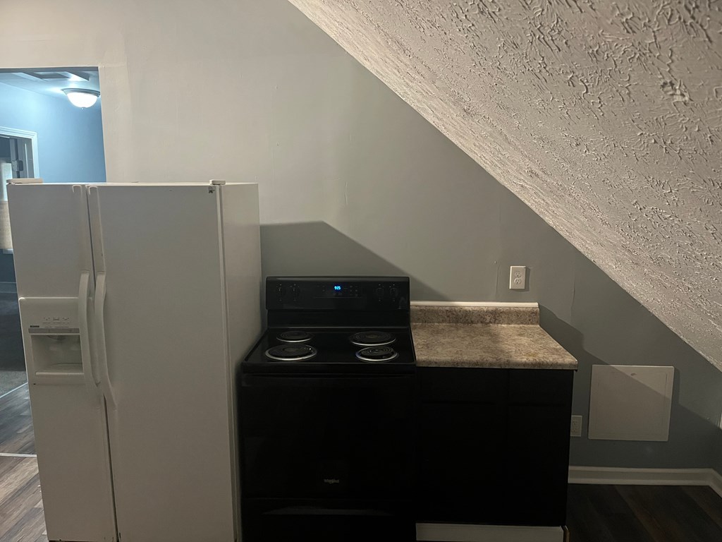 a small kitchen with a refrigerator and a stove and a refrigerator