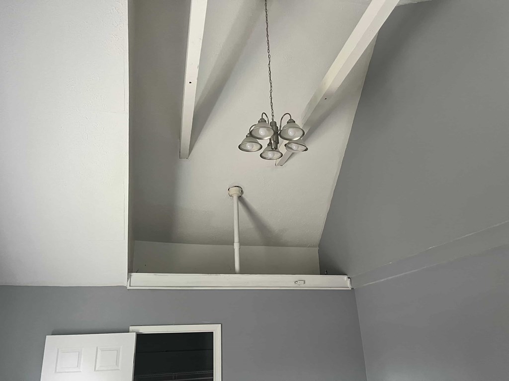 a view of the ceiling in a room with grey walls and a ceiling fan