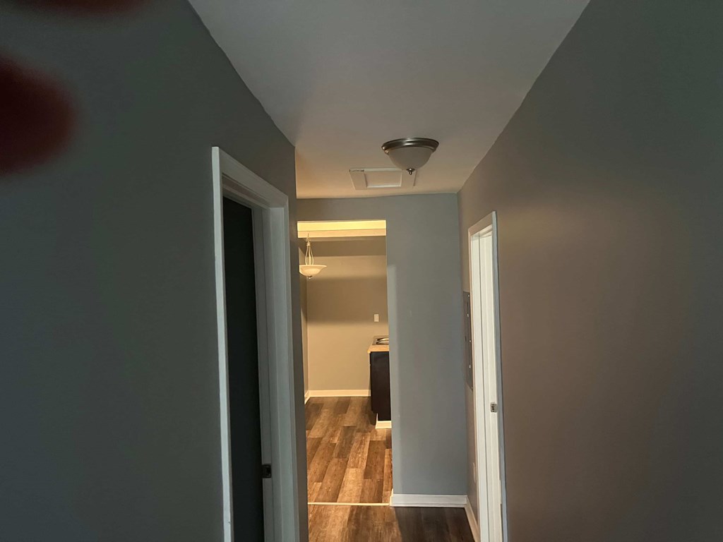 a hallway with a door to a room and a ceiling fan