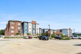 an empty parking lot in front of an apartment building
