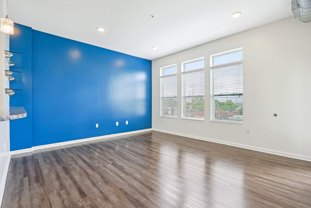 A room with a blue wall and wooden flooring.