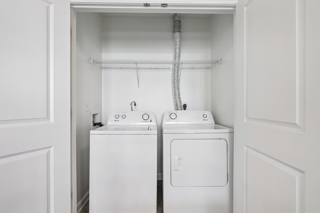 A white washing machine and dryer in a small laundry room.