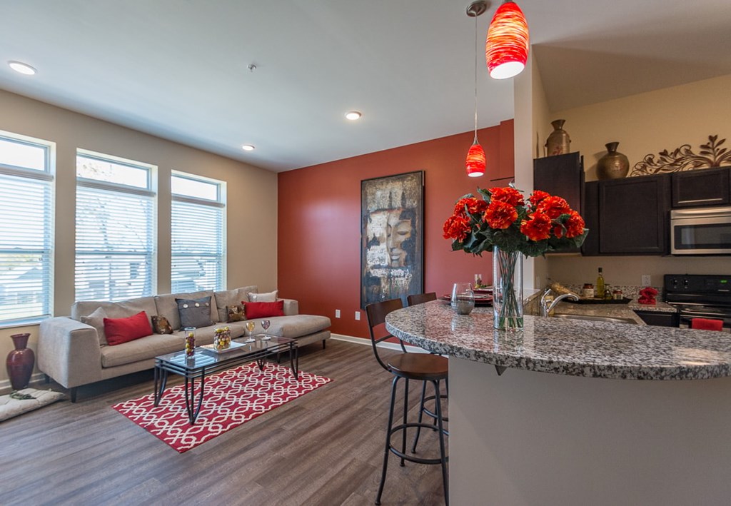 A kitchen with a bar and a red wall.