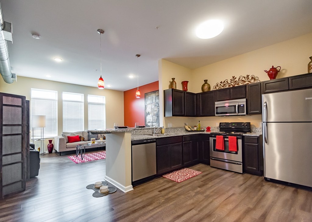 A kitchen with a refrigerator, stove, and sink.