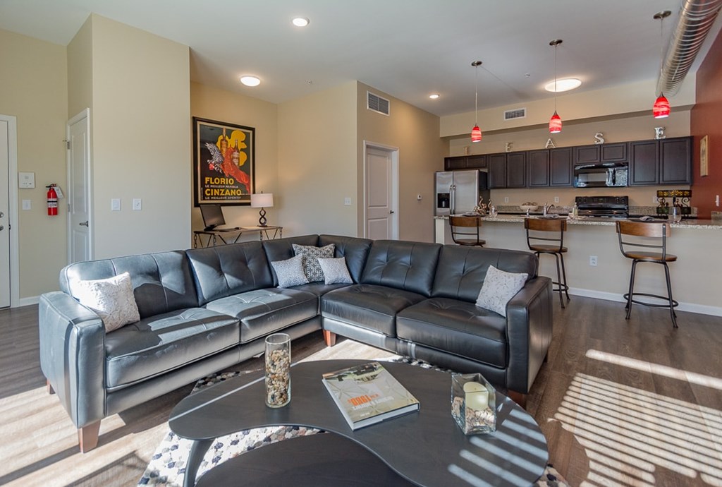 A living room with a grey leather couch and a coffee table.