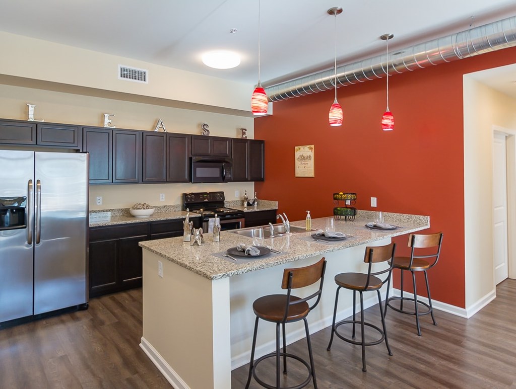 A kitchen with a bar stool and a counter.