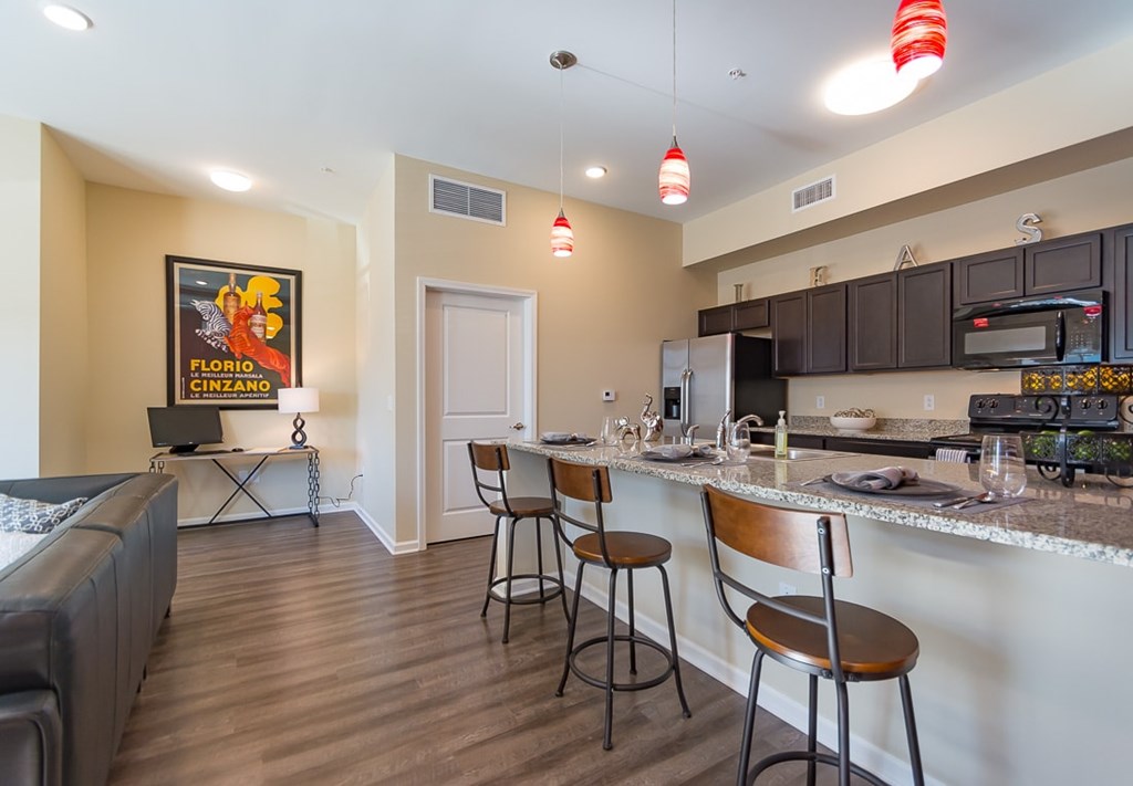 A kitchen with a bar area and a painting of Flo Biondo Cinzano.