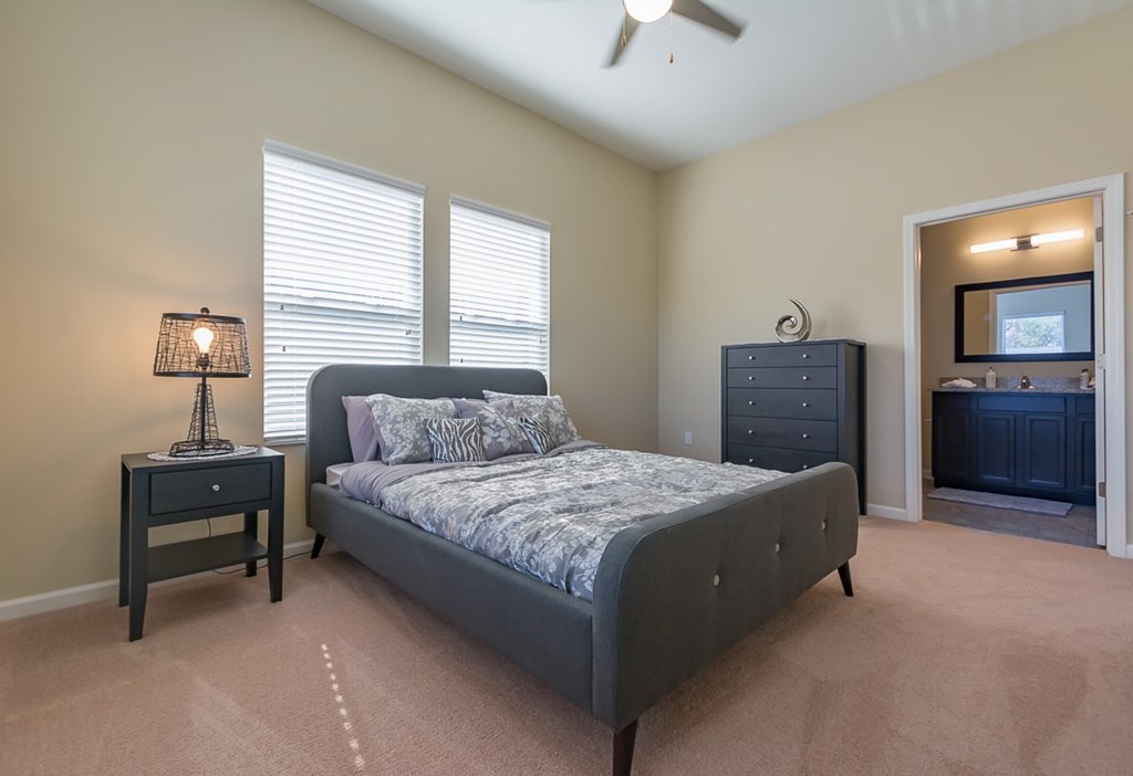 A bedroom with a bed, nightstand, and dresser.