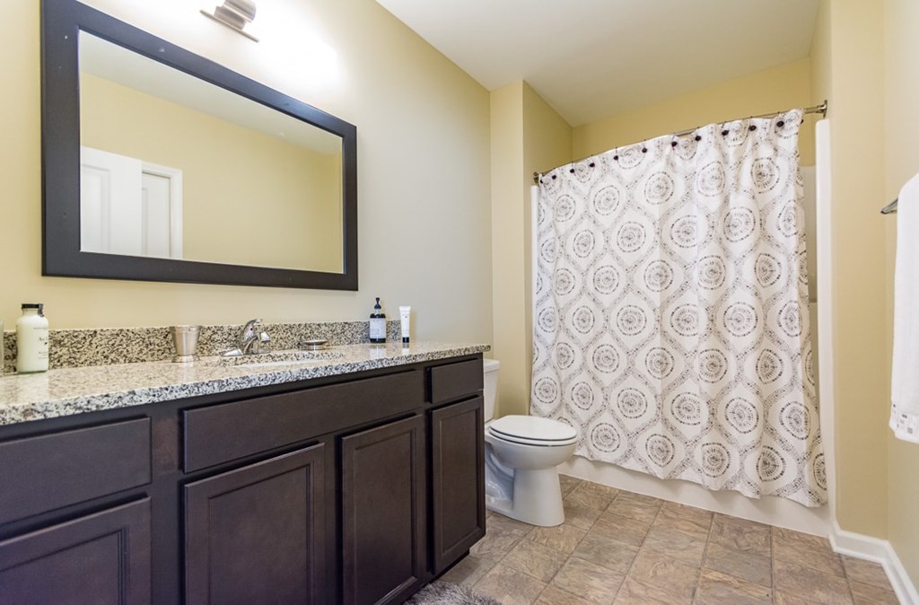 A bathroom with a toilet, sink, and shower.