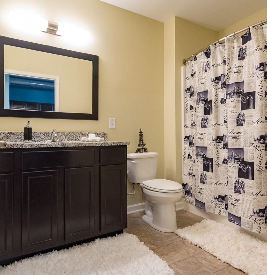 A bathroom with a toilet, sink, and shower curtain.