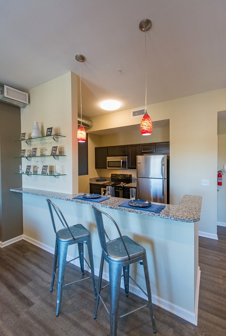 A kitchen with a bar area and two stools.