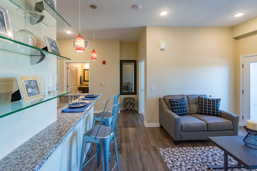 A modern living room with a dining area and a kitchenette.