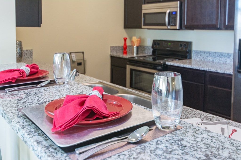 A kitchen counter with a red plate and napkin on it.