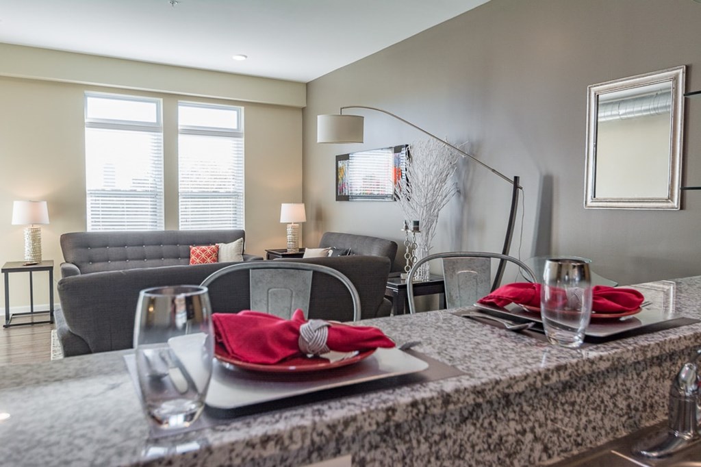 A dining table set with a red napkin and glasses.