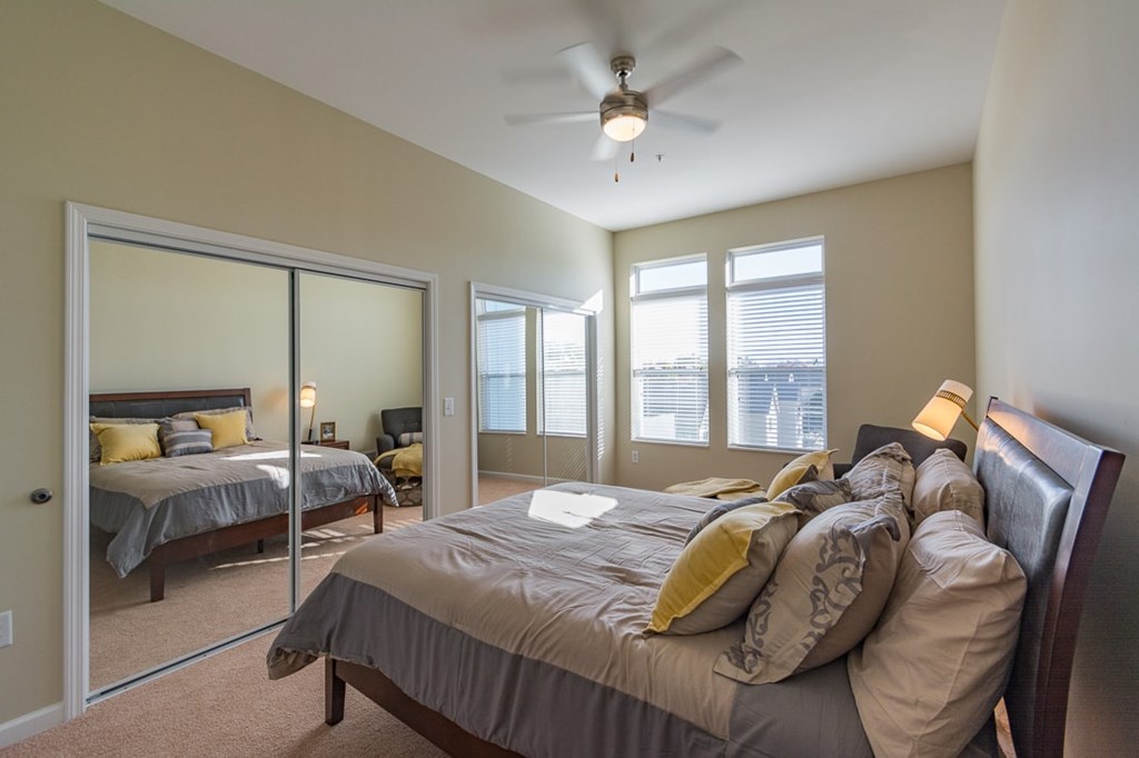 A bedroom with a large bed and a ceiling fan.