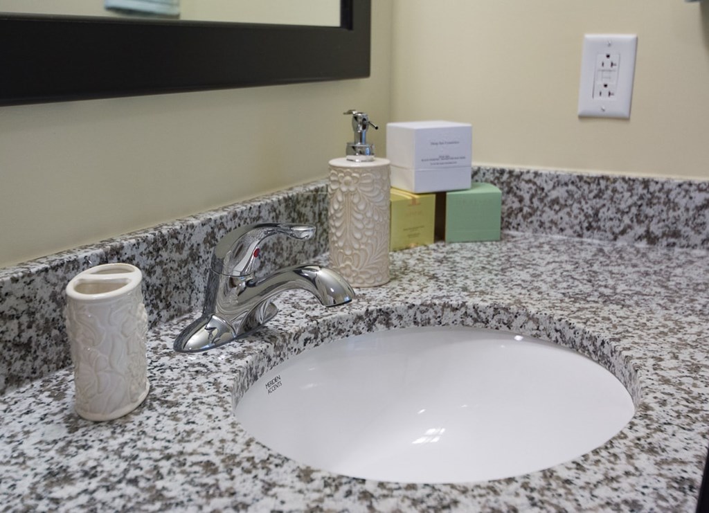 A bathroom sink with a marble countertop and a silver faucet.