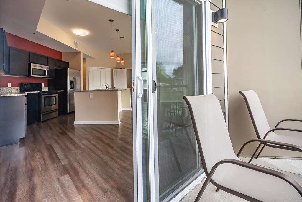 A modern kitchen with a glass door leading to a balcony.