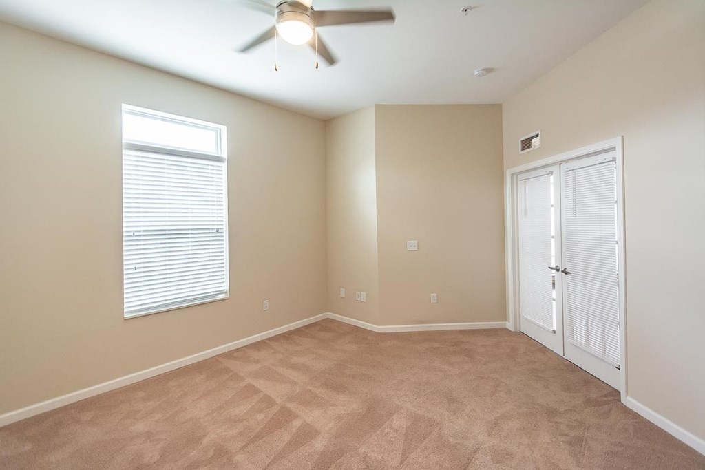 A room with a ceiling fan and a door.