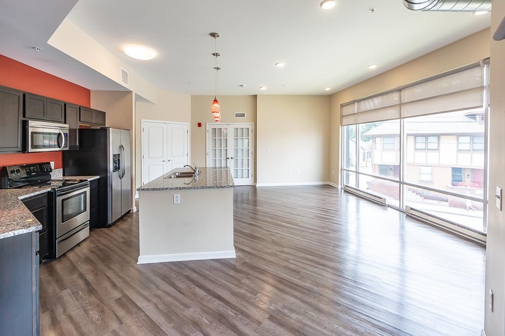 A kitchen with a refrigerator, oven, and microwave.