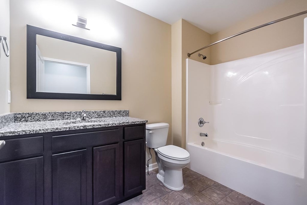 A bathroom with a toilet, sink, and bathtub.