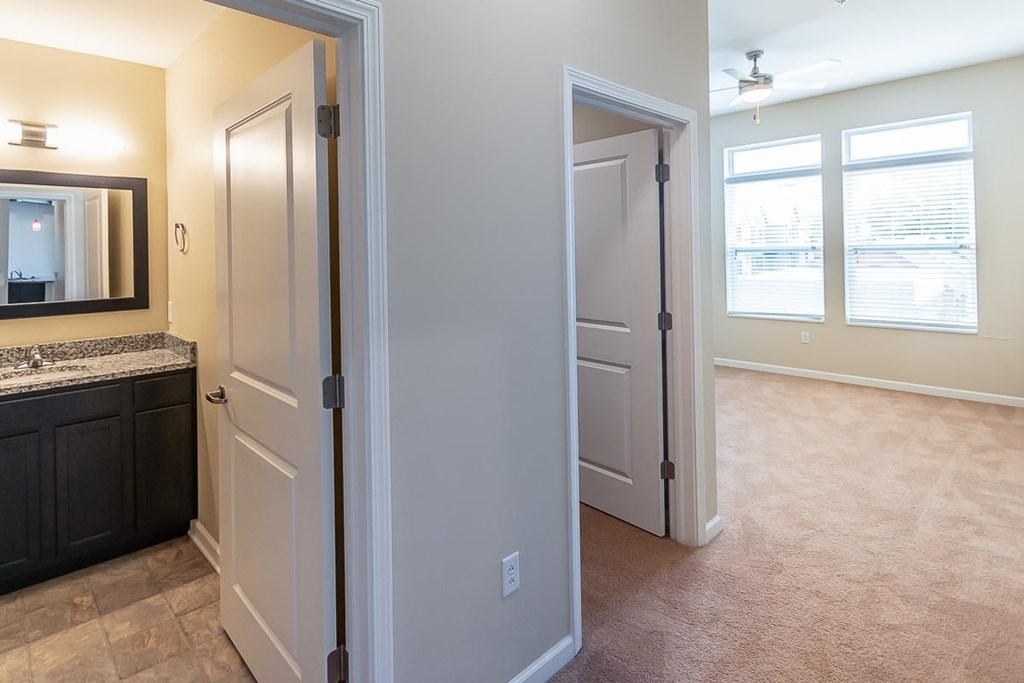 A bathroom with a sink, mirror, and two doors.