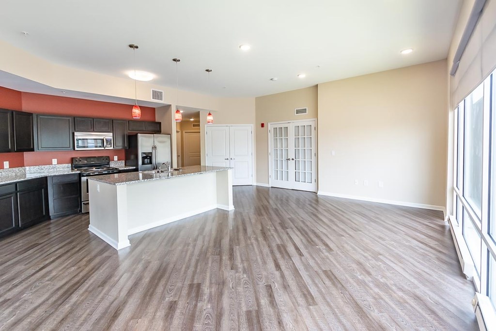 A kitchen with a white counter and wooden floors.