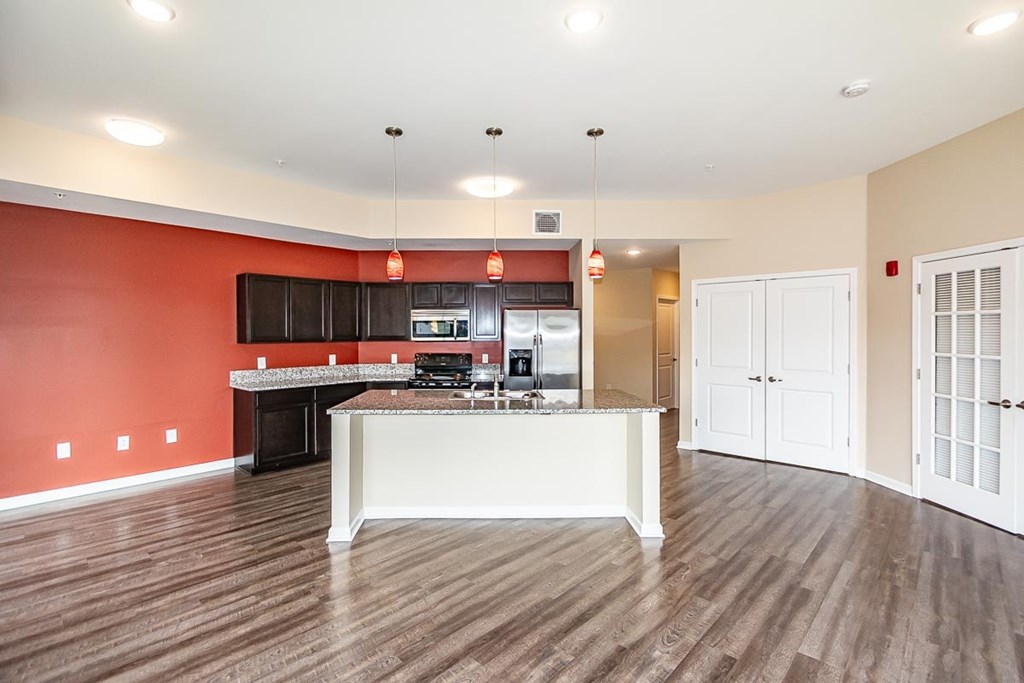 A kitchen with a white island and wooden floors.