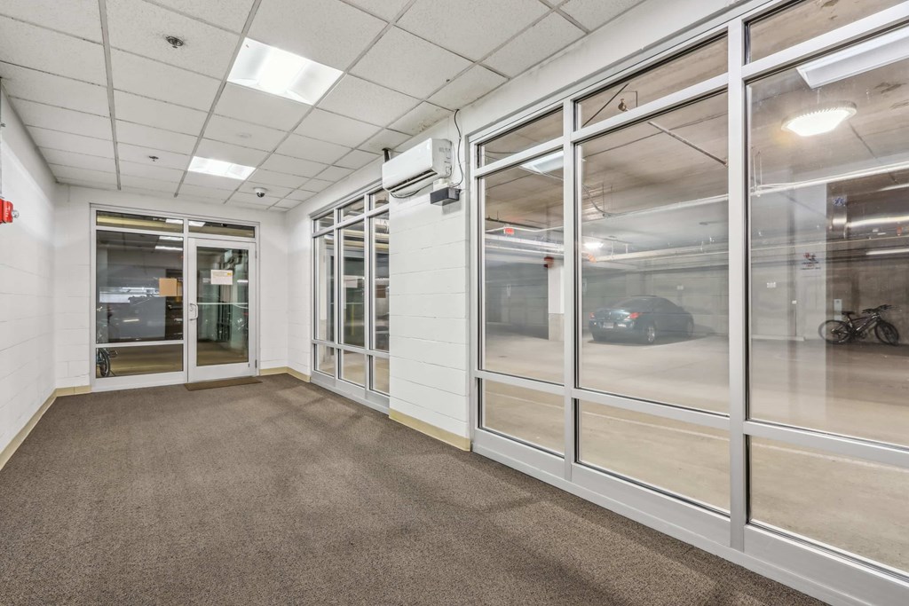 A spacious office room with large glass doors and carpeted floor.