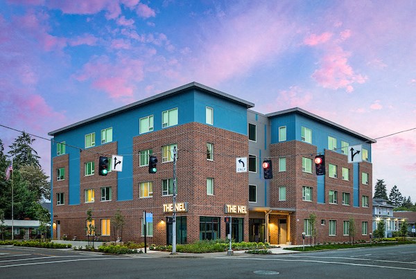 a large brick building with a blue facade on a street corner