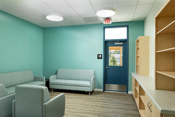a waiting room in a hospital with blue walls and chairs
