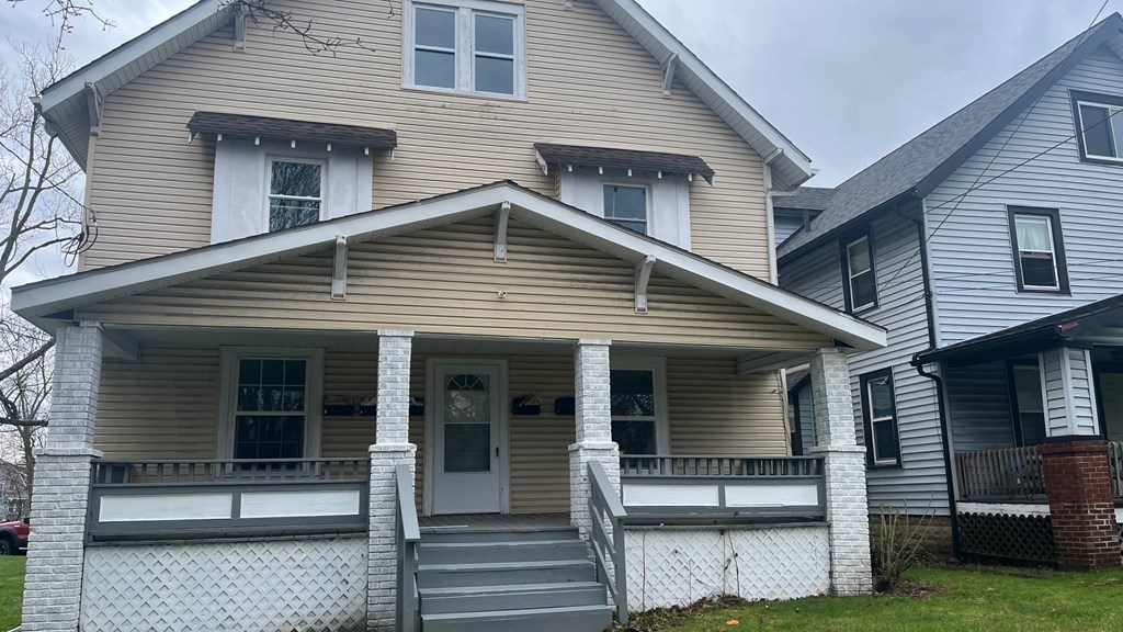 a house with a porch and a white fence