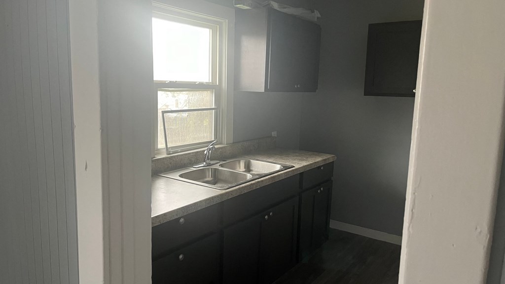 an empty kitchen with a sink and a window