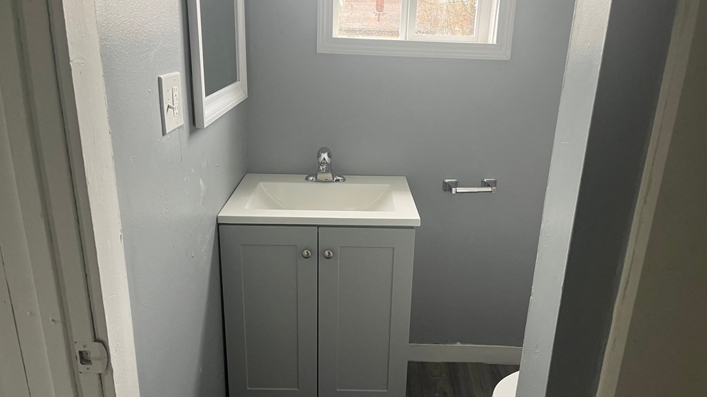 a small bathroom with a sink and a window